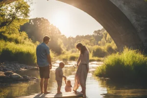 Família com pai, mãe e dois filhos posicionadas embaixo de uma ponte.