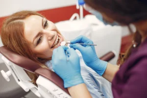 Pré-natal odontológico: gestante deitada em uma cadeira de dentista fazendo tratamento dentário.